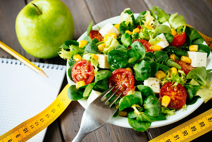 a dish of salad and an apple